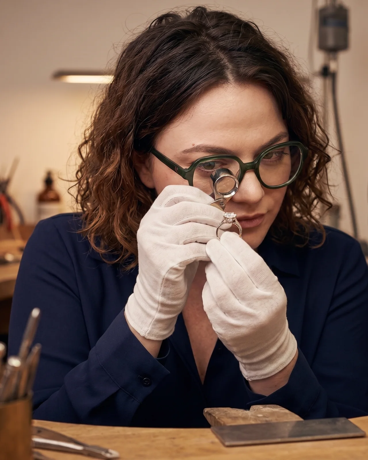 Maude Druoton, gemmologue, examinant un bijou à la loupe